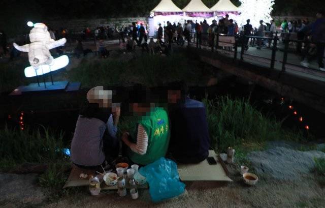 1일 오후 서울 노원구 중계동 당현천 일대에서 열리는 ‘노원 등축제’ 먹거리 부스 주변으로 술판이 벌이지고 있다.