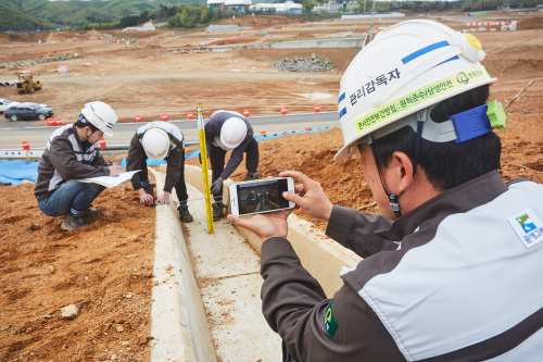 용인테크노밸리 조성공사현장에서 한화건설 직원들이 현장검측 모바일 어플리케이션을 통해 시공내역을 점검하고 있다.