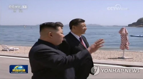 대화 나누는 김정은과 시진핑 (서울=연합뉴스) 김정은 북한 국무위원장과 시진핑 중국 주석이 중국 다롄의 휴양지 방추이다오(棒槌島) 해안가를 거닐며 대화를 나누고 있다.  [중국중앙(CCTV) 캡처=연합뉴스]      photo@yna.co.kr