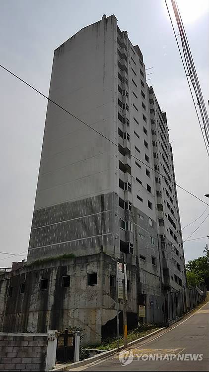 20년째 이대로… (구미=연합뉴스) 박순기 기자 = 21일 시행사 부도로 20년째 흉물로 방치된 경북 구미시 신평동 거북아트빌아파트의 모습. 15층 건물의 승강기(철 구조물)가 녹슬어 폐허가 된 아파트같이 보인다. 2018.5.21
