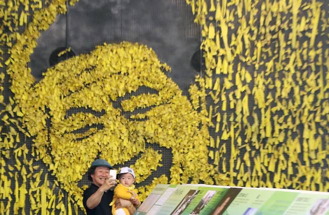 고 노무현 전 대통령 9주기 추모식이 열린 23일 경남 김해 봉하마을 노무현대통령 추모의집을 찾은 한 시민이 손자와 촬영을 하고 있다. 2018.5.23 /연합뉴스