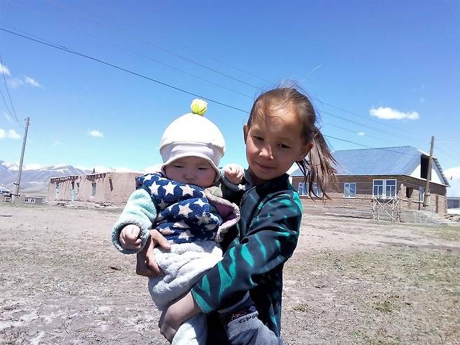 날씨 따뜻한 봄날 주흐라가 동생을 안고 바깥 구경을 시켜주고 있다.  공원국 제공