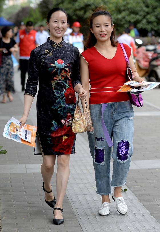 7일 중국 산둥성 시안의 한 시험장 앞에서 수험생 학부모들이 자녀들을 기다리고 있다. 자녀들의 좋은 성적을 바라는 학부모들은 전통의상인 치파오를 입고 고득점을 기원한다.[연합뉴스]