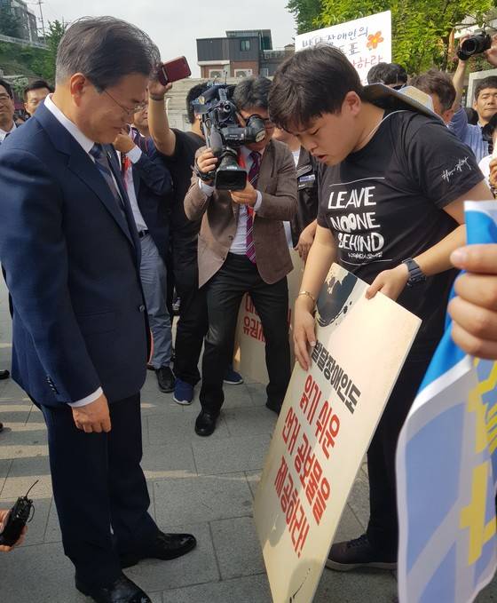 김대범씨가 8일 사전투표장에서 문재인 대통령과 만나 발달장애인 참정권 보장을 요구하고 있다. [사진 피플퍼스트]