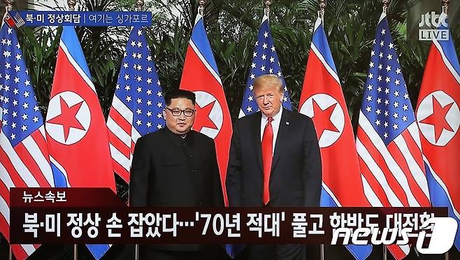 도널드 트럼프 미국 대통령과 김정은 북한 국무위원장이 12일 오전 북미 정상회담이 열리는 싱가포르 센토사섬 카펠라호텔에서 악수를 나눈 후 기념촬영을 하고 있다. (jtbc 캡쳐) 2018.6.12/뉴스1 © News1 임세영 기자