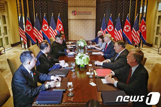 도널드 트럼프 미국 대통령과 김정은 북한 국무위원장이 12일 오전 북미 확대 정상회담이 열린 싱가포르 센토사섬 카펠라호텔에서 대화를 나누고 있다. (싱가포르통신정보부 제공) 2018.6.12/뉴스1