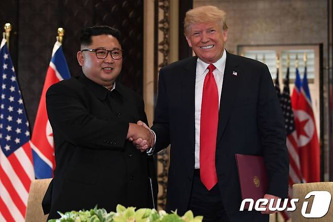 김정은 북한 국무위원장과 도널드 트럼프 미국 대통령이 12일(현지시간) 싱가포르 센토사 섬 카펠라 호텔에서 140여 분에 걸친 단독·확대정상회담과 업무오찬을 마친 뒤 북미정상회담 공동합의문에 서명 후 악수를 하고 있다. © AFP=뉴스1