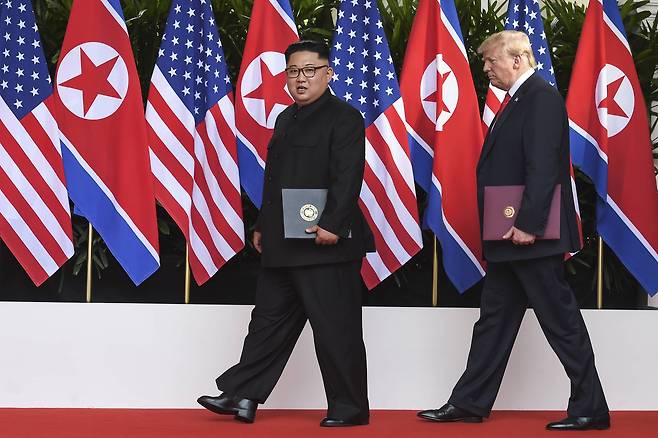 김정은 북한 국무위원장과 도널드 트럼프 미국 대통령이 합의문을 들고 화랑을 빠져나가고 있다. 나란히 걷는 양 정상의 키가 엇비슷하다. [AP=연합뉴스]