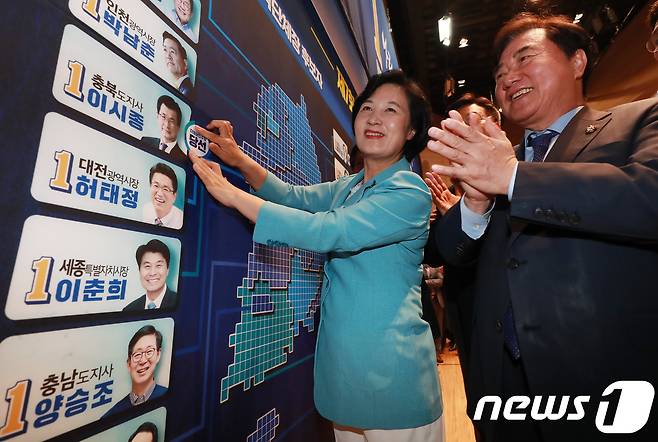 추미애 더불어민주당 대표가 13일 오후 서울 여의도 국회 의원회관에 마련된 선거상황실을 찾아 당선이 확실한 광역단체장 후보자·국회의원 재보궐선거 후보자에 당선표를 붙이고 있다. 2018.6.13/뉴스1 © News1 이동원 기자