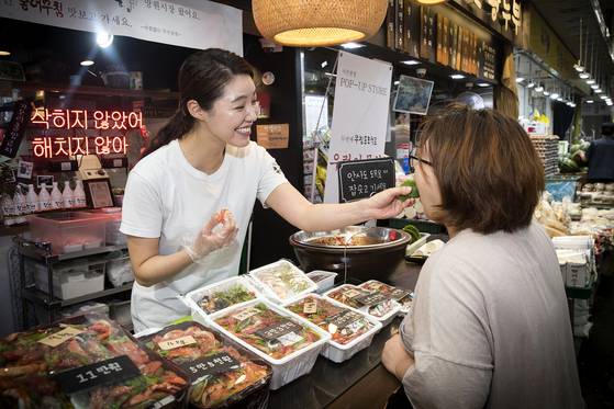 전 씨가 손님에게 시식을 권하고 있다. 장진영 기자