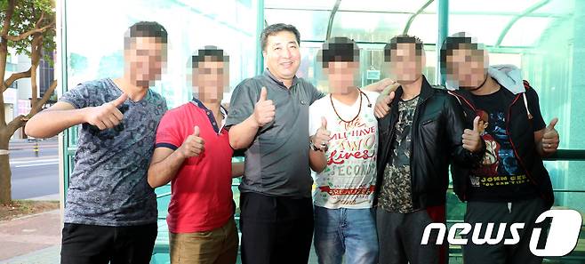 자신이 운영하는 호텔에서 100여 명이 넘는 예멘 난민들의 숙식을 지원해 온 김우준 대표(54)가 호텔 앞에서 예멘 난민들과 함께 촬영을 하고 있다.2018.6.22/뉴스1© News1