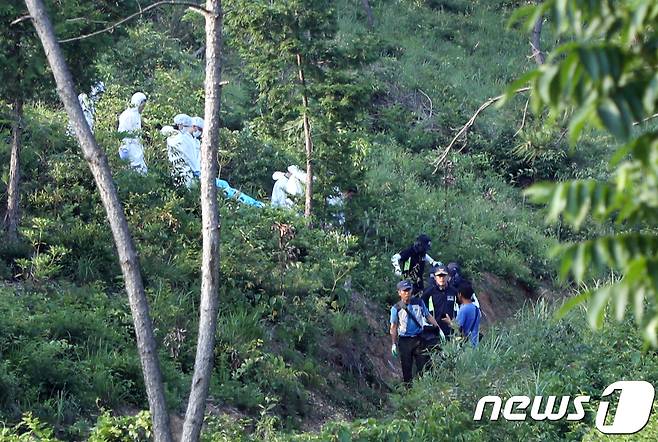 경찰과학수사대 대원들이 24일 전남 강진군 도암면 지석리 야산 정상 부근에서 지난 16일 아르바이트를 한다고 집을 나선 후 실종됐던 A양(16)으로 추정되는 시신을 발견해 구급차로 옮기고 있다. 2018.6.24/뉴스1 © News1 한산 기자