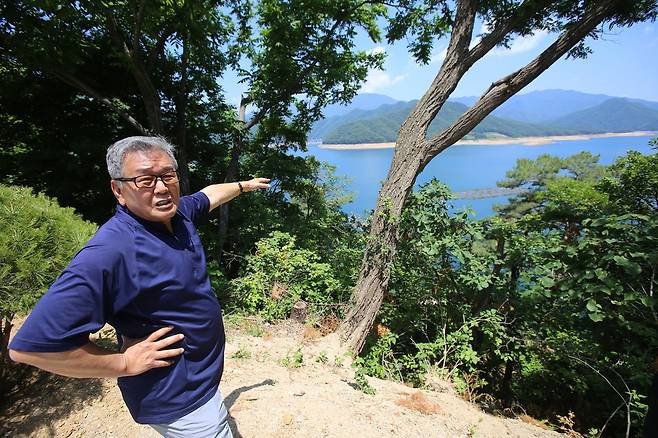 허장환 한중국제우호연락평화촉진회 공동대표가 한·미 연합군이 중장비를 이용해 중국군 포로를 밀어넣었다는 장소에 서서 상황을 설명하고 있다.