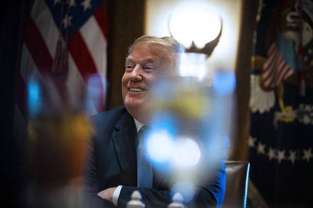 미 워싱턴DC 백악관에서 26일(현지시간) 도널드 트럼프 미 대통령이  공화당 의원들과 오찬 회동 중 미소를 지으며 발언을 하고 있다. 이날 미 연방대법원은 하와이 주 정부가 제기한 이슬람권 5개국 국민의 미국 입국을 제한하는 '반이민 행정명령'의 위헌소송 최종심에서 원고패소 판결을 내렸다. EPA 연합뉴스