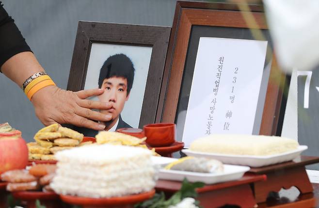수은 온도계 제조업체에서 일하던 15살 소년 문송면군이 수은 중독으로 세상을 떠난 지 30년이 흘렀다. 1일 경기도 남양주시 모란공원에서 열린 산재 노동자 합동추모제에서 한 참석자가 문군의 영정사진 위에 떨어진 빗물을 닦고 있다. 하지만 여전히 지금 이 시대에도 또 다른 문송면이 남아 있다. 삼성반도체에서 쓰러진 황유미씨, 제주도 제조업체 컨베이어 벨트 앞에 서 있던 이민호군, 북극항로를 나는 비행기 안 대한항공 승무원들까지… 더 이상 기업의 희생자가 되는 노동자는 없어야 하지 않겠는가. 백소아 기자 thanks@hani.co.kr