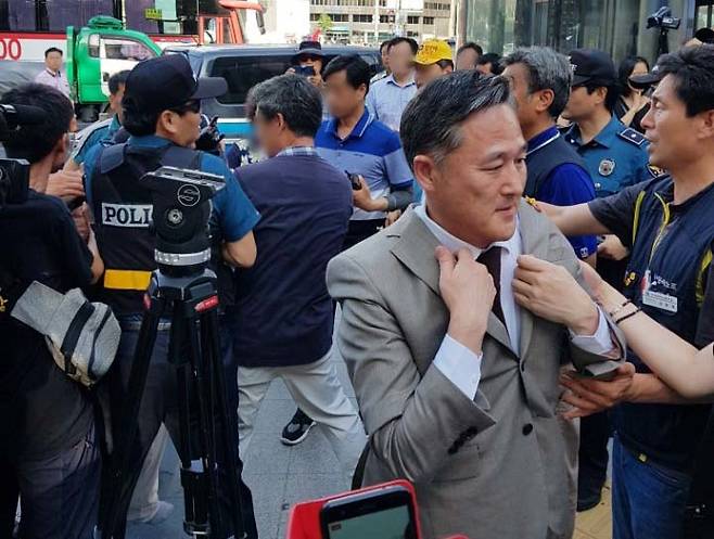 표창원 더불어민주당 의원이 같은 당 박주민 의원과 함께 4일 오후 서울 중구 대한문 앞에 마련된 금속노조 쌍용차지부의 노조원 분향소를 찾았다가 친박 단체인 태극기행동국민운동본부 관계자로 추정되는 남성으로부터 거세게 뒷덜미를 잡혔다. 경찰과 주변인들이 이 남성을 떼어내자 표 의원이 옷매무시를 가다듬고 있다. [연합뉴스]