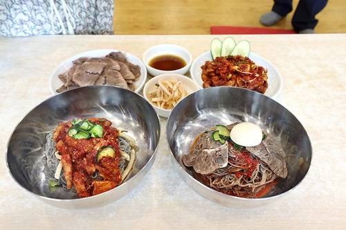 회비빔냉면과 고기비빔냉면 상차림. 소고기수육, 수육간장, 무김치, 회무침이 반찬으로 놓였다 [사진/조보희 기자]