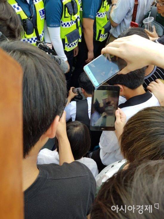 인터넷 방송인 액시스마이콜이 7일 오후 4시께 경찰 통제선을 뚫고 집회 현장에 진입하려다 제지당하자 바닥에 앉아 개인 영상을 생중계하며 부당함을 호소하고 있다.(사진=문혜원 기자)