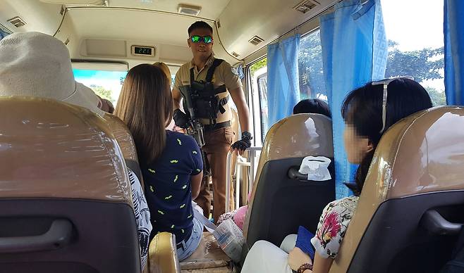 필리핀 팔라완 이와힉 개방 교도소 입구에서 총을 든 교도대원이 관광객이 탄 차량 내부를 살펴보고 있다. 변선구 기자