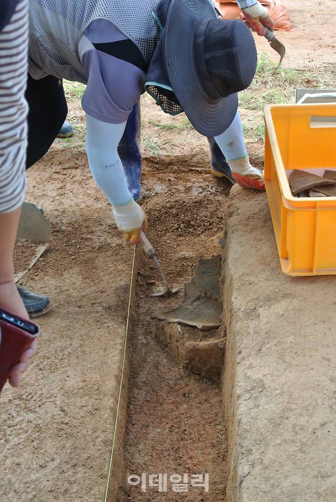 학자들이 익산 왕궁리 유적에서 출토한 기왓장 사이를 조심스레 호미로 긁어내고 있다. 이곳에서 백제시대 궁장, 석축, 대형화장실, 정원, 와적기단 건물지, 공방 폐기지, 후원 영역의 도수 등 다양한 왕궁 관련 유구가 나왔다. (사진=이정현 기자)