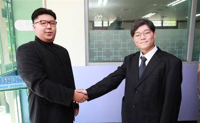 16일 경기도 의정부고등학교 학생들이 다양한 분야를 풍자하는 졸업 사진을 찍었다. 의정부고는 매년 졸업 사진에 이슈가 됐던 인물과 사건을 담아 큰 관심을 받고 있다. 두 학생이 문재인(오른쪽) 대통령과 김정은(왼쪽) 북한 국무위원장으로 분장해 남북 정상이 지난 4월 27일 판문점에서 만나 악수한 모습을 따라하고 있다. 뉴스1