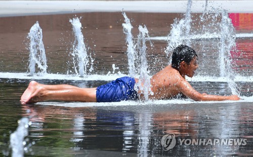 미 로스앤젤레스의 한 공원에서 한 소년이 더위를 피해 물놀이를 하고 있다. [AFP=연합뉴스]