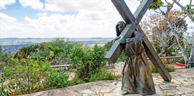 올긴주의 랜드마크인 라 로마 데 라 크루스 언덕 위 십자가를 지고 있는 청동상