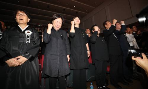 26일 연세대 대강당에서 열린 고 노회찬 정의당 원내대표 추모제에서 부인 김지선씨, 심상정 전 대표, 이정미 대표 등이 눈물을 참으며 임을 위한 행진곡을 부르고 있다. 연합뉴스