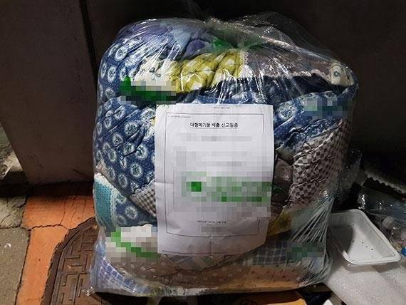 대형 폐기물 배출 신고 필증이 부착되어 있는 이불과 베개. 서울시 자치구 25개구 중 24개구에서 신청할 수 있다. /사진=이혁 기자