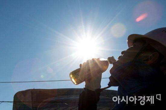 서울 한 낮 최고 기온이 40도 가까이 오를 것으로 예보된 1일 서울 중구 한 건설현장에서 근로자가 쉬는 시간을 이용해 목을 축이고 있다./강진형 기자aymsdream@