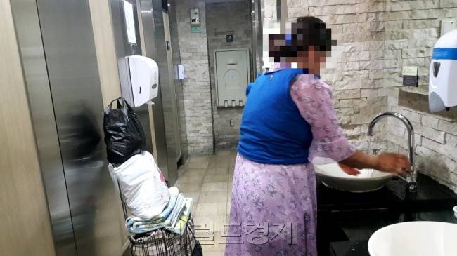 지난 7월 11일 서울 영등포구에 있는 한 공원에서 만난 여성 노숙인이 인근 백화점에서 세수를 하고 있다. [정세희 기자/say@heraldcorp.com]