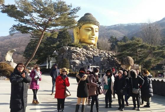 지난 7일 오전 거대한 황금빛 불두(佛頭·부처 머리) 등이 유명한 경기도 용인 와우정사 경내를 동남아 관광객들이 둘러보고 있다. [와주정사 제공]