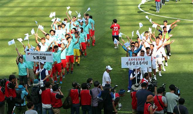 11일 오후 서울월드컵경기장에서 열린 남북노동자통일 축구대회에서 남북 노동자 대표 선수들이 관중들에게 인사를 하고 있다. 연합뉴스