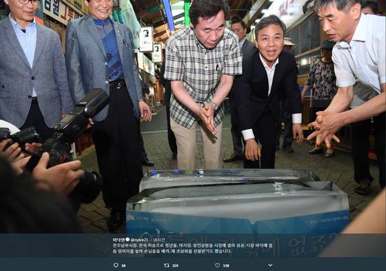 11일 전주 남부시장을 찾은 이낙연(체크무늬 남방) 국무총리가 김승수(검정 정장) 전주시장과 하현수(하늘색 남방) 남부시장 상인회장과 함께 더위를 식혀 주는 얼음 덩어리를 만져 보고 있다. [사진 이낙연 총리 트위터 캡처]