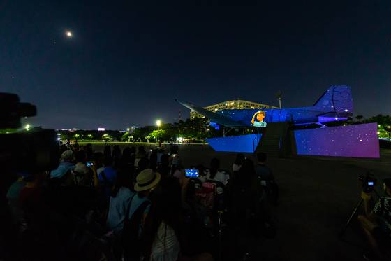 17일 오후 서울 여의도공원 C-47 비행기 전시관에서 '여의도공원 비행기 영상쇼 - 어느 소년 광복군의 비행' 미디어파사드 공연이 열리고 있다. [사진 3·1운동 100주년 서울시기념사업사무국]