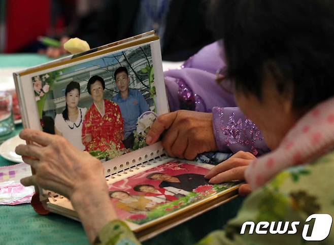 제21차 이산가족 상봉행사 1회차 첫날인 20일 오후 금강산호텔에서 열린 단체상봉에서 한신자(99)할머니가 북측의 딸들 김경실(72), 김경영(71)의 사진을 살펴보고 있다. 2018.8.20/뉴스1 © News1 뉴스통신취재단