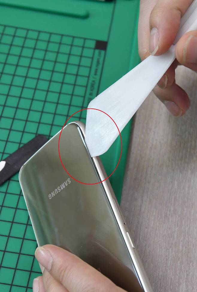 짝퉁 갤럭시S6는 뾰족한 막대를 틈새로 넣었더니 쉽게 기기를 분리할 수 있었다. 김동욱기자 gphoto@etnews.com