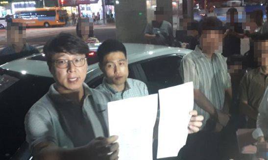 지난달 30일 오후 8시40분께 입주자대표회의 회장 B씨(사진 왼쪽)가 A 씨가 자필로 작성한 사과문을 발표하고 있다.사진=한승곤 기자 hsg@asiae.co.kr