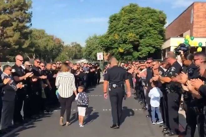 수십명의 동료들에게 에워싸인 그레그.