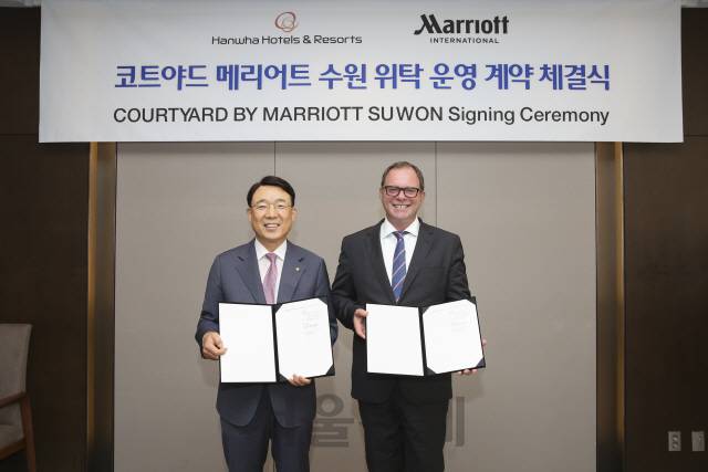 김영철(왼쪽) 한화호텔앤드리조트 호텔부문 대표와 피터 가스너 메리어트 인터내셔널 부사장이 7일 코트야드 메리어트 수원 위탁운영 계약 체결식에서 기념촬영을 하고 있다. /사진제공=한화호텔앤드리조트