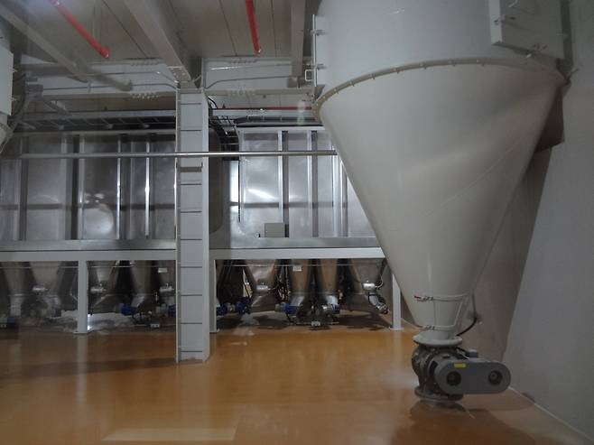 각 원료를 저장고에 담아 보관한다. 저장고에 담긴 원료는 천정에 설치된 은색 기둥을 타고 다음 공정으로 넘어간다.