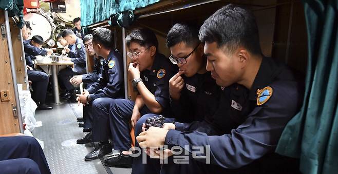 잠수함 내 별도의 식사 및 휴식 공간이 없어 침실 한켠 식탁에서 식사 중인 승조원들과 식사를 마치고 침상에 걸터앉아 후식을 먹고 있는 승조원들의 모습. [사진=해군]