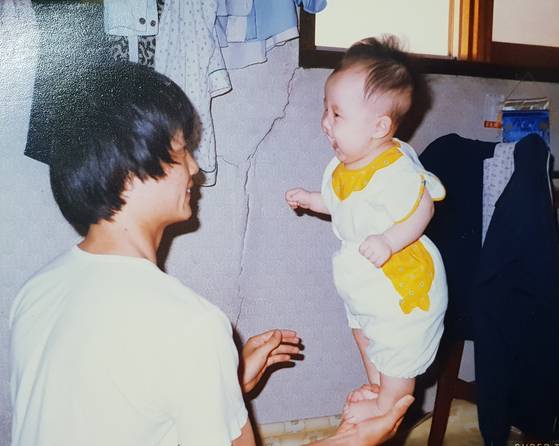 아빠는 무뚝뚝한 성격으로 나를 "우리 딸"이라고 불러본 적도 없다. 20대까지는 그런 아빠한테 많이 섭섭하기도 했지만 최근에는 아빠 나름의 방식으로 사랑을 주는 게 느껴진다. 지금은 고민이 있을 때마다 든든한 상담자 역할을 해주신다. 사진은 내가 6개월 때 아빠가 놀아주는 모습. 아빠는 지금도 돌이 안 된 작은 아기를 보면 한손에 올려 놀아주신다. [사진 서영지]