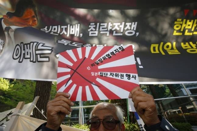 2015년 4월 서울 일본대사관 앞에서 열린 ‘아베 총리 미 의회 연설 규탄·신 미일 방위협력지침 폐기 촉구 기자회견’에서 한 시민이 구호를 적은 욱일기를 들어보이고 있다. 김봉규 기자 bong9@hani.co.kr