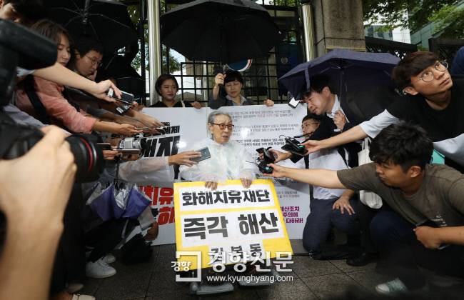 일본군 위안부 피해자인 김복동 할머니가 지난달 3일 서울 종로구 외교통상부 청사 앞에서 화해·치유재단 해산을 촉구하는 1인 시위를 하던 중 일본 아사히신문 기자(오른쪽 위)와 이야기하고 있다. 김창길 기자 cut@kyunghyang.com
