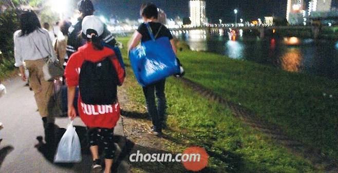 사쿠라강… 쓰레기 들고 떠나는 시민들 - 6일 밤 일본 3대 불꽃놀이 축제가 열린 이바라키현 쓰치우라(土浦)시 사쿠라강에서 시민들이 각자 자기가 만든 쓰레기를 한 손에 들고 귀가하고 있다. /쓰치우라=최은경 특파원