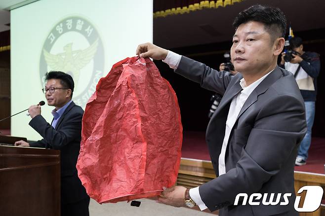 9일 경기 고양경찰서에서 열린 고양저유소 화재 사건 중간수사결과 브리핑에서 수사관계자가 화재 원인이 된 풍등과 같은 종류의 풍등을 공개하고 있다. 경기 고양경찰서는 이날 브리핑에서 스리랑카인 A씨(27)가 7일 오전 10시 55분께 고양 덕양구 화전동 대한송유관공사 경인지사 저유소 인근 야산 강매터널 공사장에서 풍등을 날려 화재가 발생했다고 밝혔다.  2018.10.9/뉴스1 © News1 유승관 기자