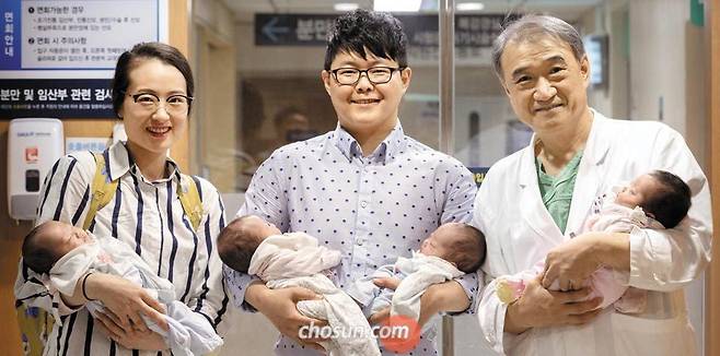 지난달 17일 서울대병원 산부인과 분만장 앞에서 네 쌍둥이 부모 김정화(32)·홍광기(32)씨와 서울대병원 산부인과 전종관(59) 교수(왼쪽부터)가 생후 두 달 된 아기 넷을 품에 안고 활짝 웃고 있다. /김지호 기자