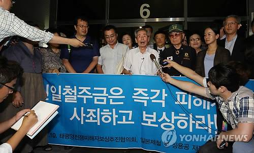 2013년 7월 서울 서초동 서울고등법원 앞에서 일본 강제징용 피해자 여윤택(가운데) 씨와 변호인단, 지원단체들이 신일본제철 주식회사를 상대로 한 손해배상 소송의 파기환송심에서 일부 승소한 뒤 법정 앞에서 판결에 대한 입장을 설명하고 있다. [연합뉴스 자료사진]