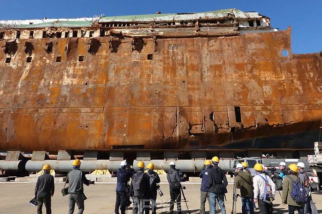 ▲ 19일 기자들이 세월호 좌현 외부 충돌 흔적 모습을 바라보고 있다. 사진=김예리 기자